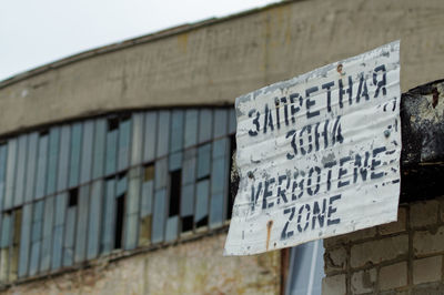 Low angle view of information sign on wall of building