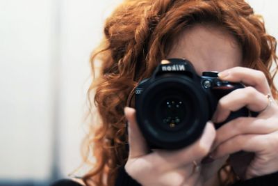 Close-up of young woman photographing camera