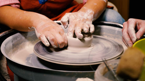 A female expert potter teaches viewers the art of pottery. close-up of her hands working with clay