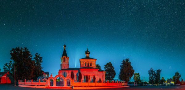 Illuminated building against clear sky at night