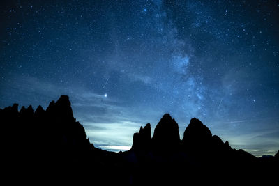 Low angle view of silhouette rocks against sky at night