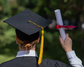 Midsection of woman wearing graduation gown