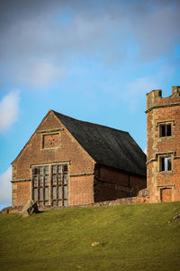 Old house on field against sky