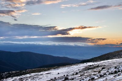 Scenic view of snowcapped mountains against sky during sunset