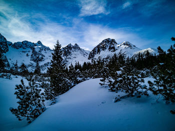 Scenic view of snowcapped mountains against blue sky