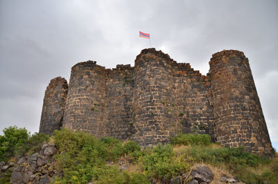 Low angle view of castle on mountain against sky