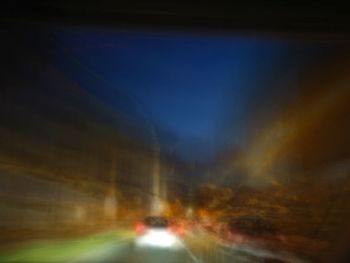 Cars on road against sky at night