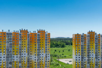 Buildings in city against clear blue sky