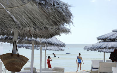 People at beach against sky