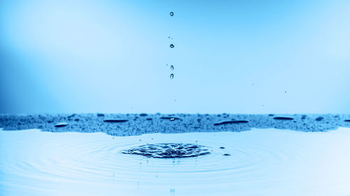 Close-up of splashing water against blue sky