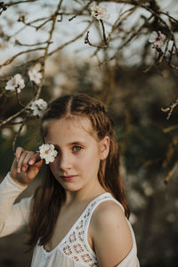 Portrait of beautiful woman with red flowers