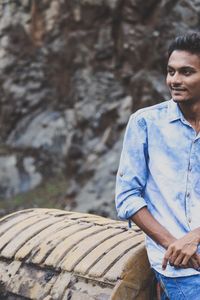 Thoughtful man looking away while leaning on bulldozer