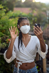 Young black woman in face mask doing a video call