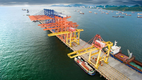 High angle view of commercial dock by sea against sky