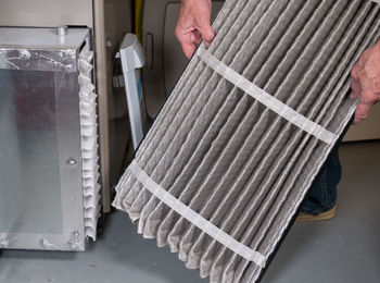 Low angle view of man holding air conditioner filter