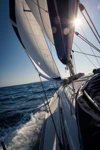 Sailboat sailing on sea against sky
