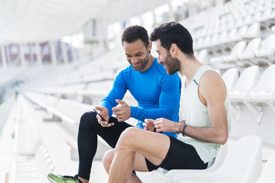 Young male athletes sitting on seat in stadium