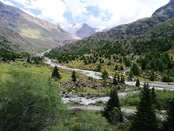 Scenic view of green landscape and mountains against sky