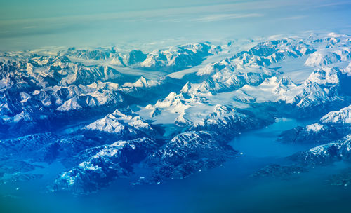 Scenic view of snowcapped mountains and sea against sky