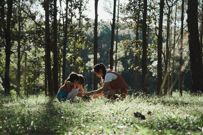 Mother playing with kids in forest