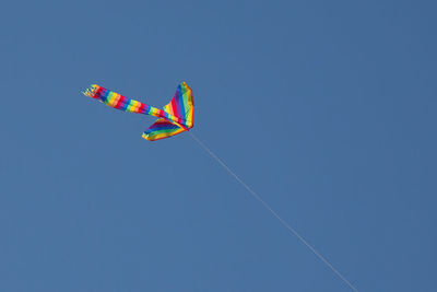 Low angle view of balloons against clear blue sky