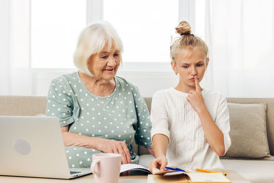 Friends using laptop at home