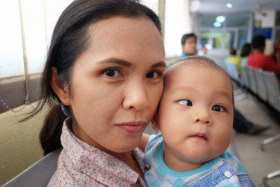 Portrait of woman with baby in hospital