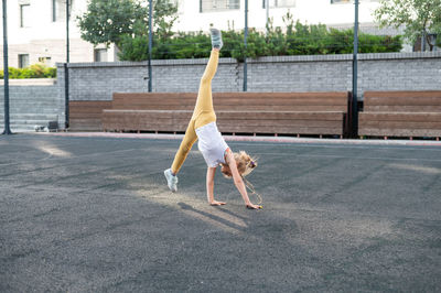 Full length of woman exercising on road