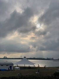 People on beach against sky during sunset