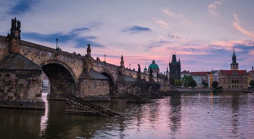 Bridge over river against cloudy sky