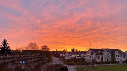 Houses in town against sky at sunset