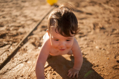 Portrait of cute boy lying on sand