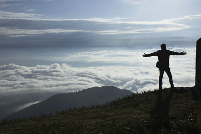 Silhouette man standing on mountain against sky during sunset