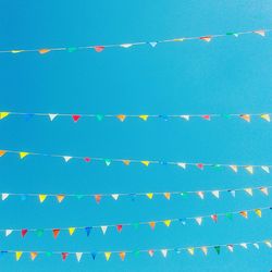 Multi colored buntings against clear blue sky