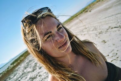 Close-up of young woman at beach against clear sky