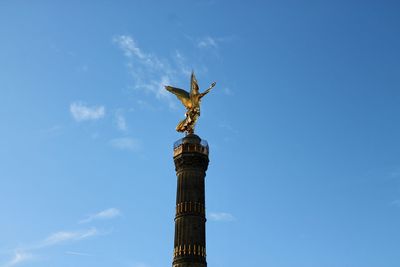 Low angle view of angel statue against blue sky