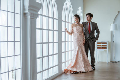 Full length of bride and bridegroom standing in office