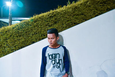 Portrait of young man standing against trees