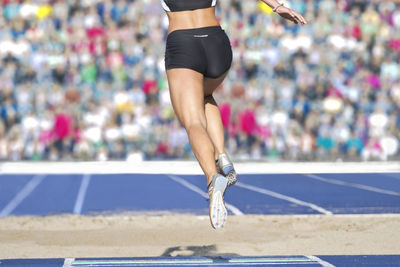 Low section of female athlete running on track