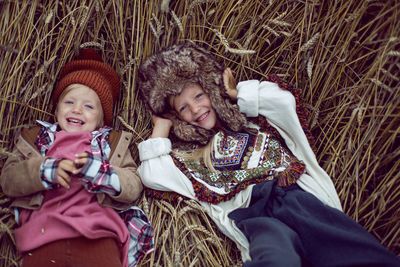 Two stylish sisters lie in a field with wheat in the autumn
