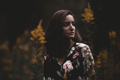 Thoughtful young woman looking away in park during autumn