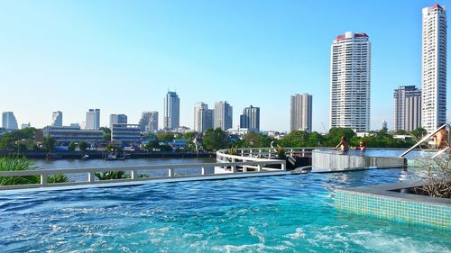 Swimming pool in hotel against cityscape