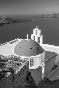 Traditional building by sea against sky