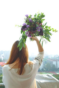 Rear view of woman holding flower