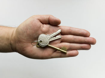 Close-up of man holding hands over white background