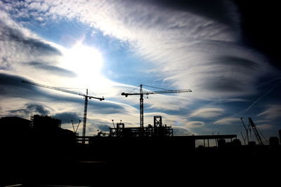 Low angle view of silhouette electricity pylon against sky