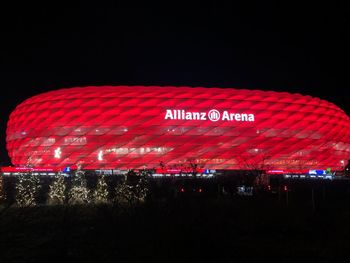 Illuminated text on field against clear sky at night