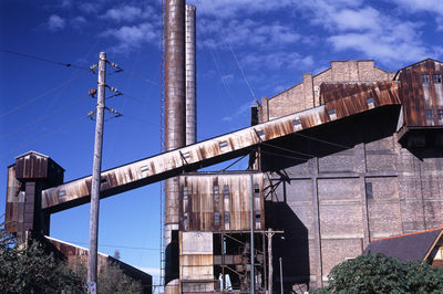 Abandoned white bay power station against sky