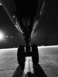 Illuminated lighting equipment on road against sky at night