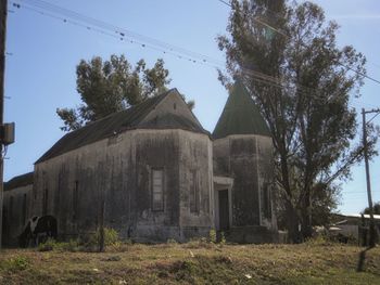 Old abandoned house on field against sky